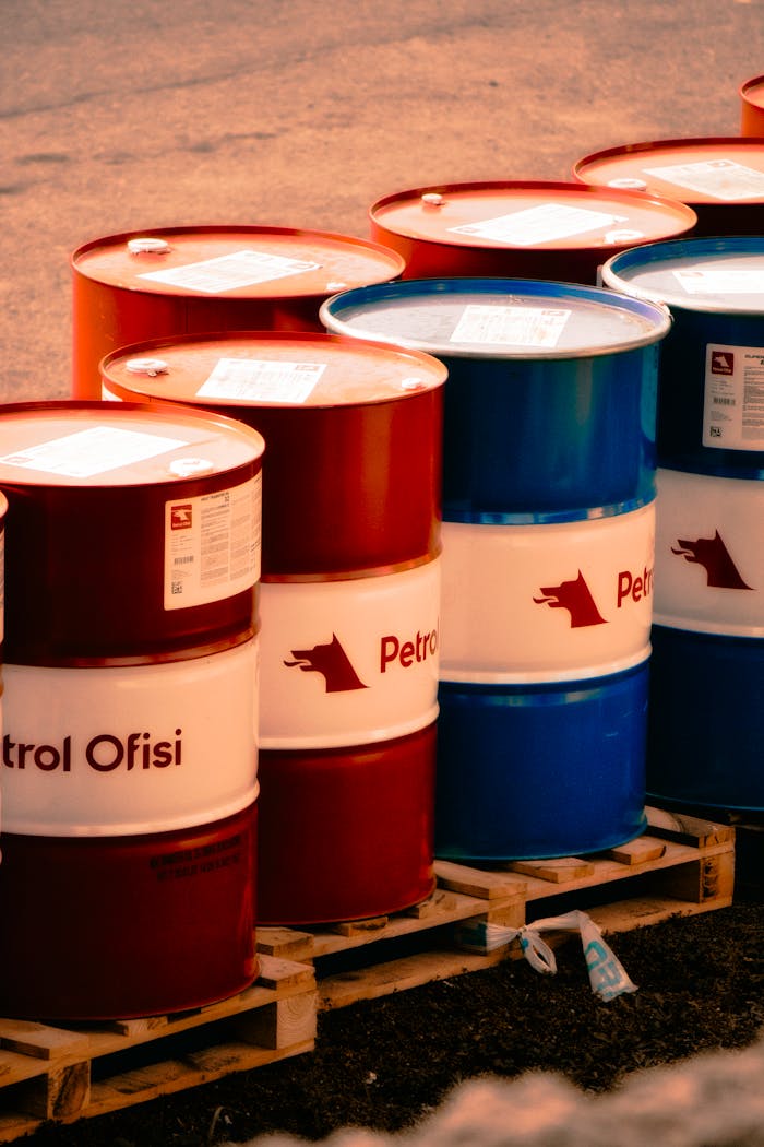 about-01 A collection of red and blue oil barrels labeled 'Petrol Ofisi' in an outdoor industrial setting in Turkey.